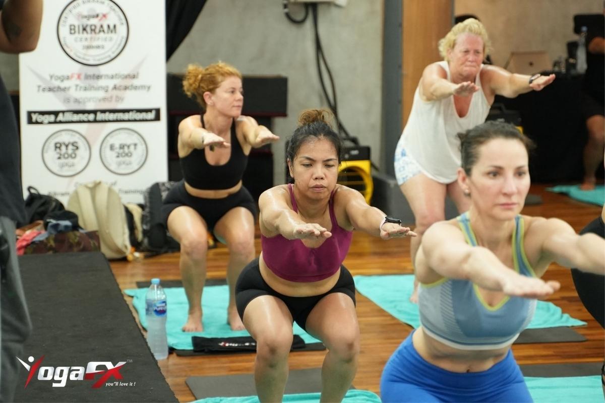 Bikram yoga for beginners first class at YogaFX Bali showing new practitioners following verbal instruction in natural tropical heat
