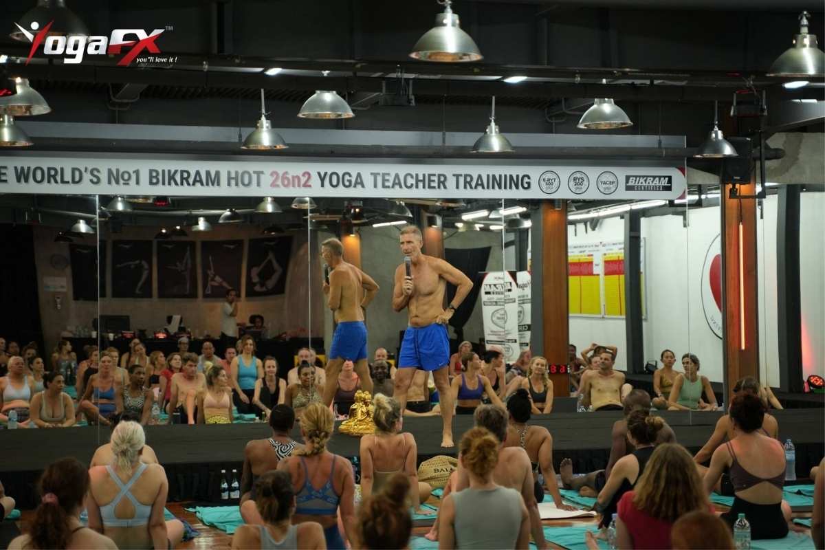 Bikram yoga dialogue teaching mistakes guide showing YogaFX instructor at front of class observing room during 26 and 2 yoga class Bali