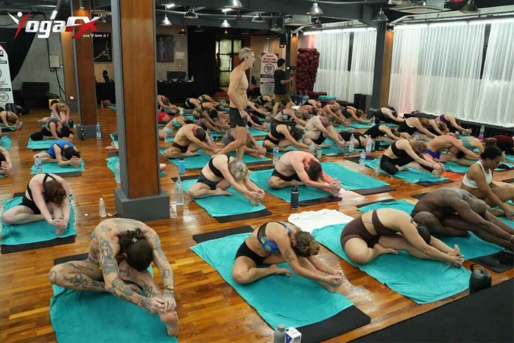 Bikram yoga dialogue teaching mistakes guide showing YogaFX instructor at front of class observing room during 26 and 2 yoga class Bali