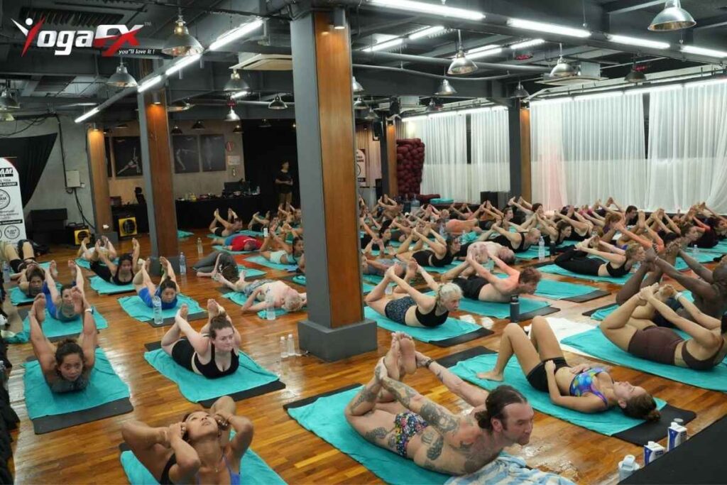 Beginner modification of Bow Posture in Bikram yoga showing one-leg version with single ankle grip for practitioners new to the posture