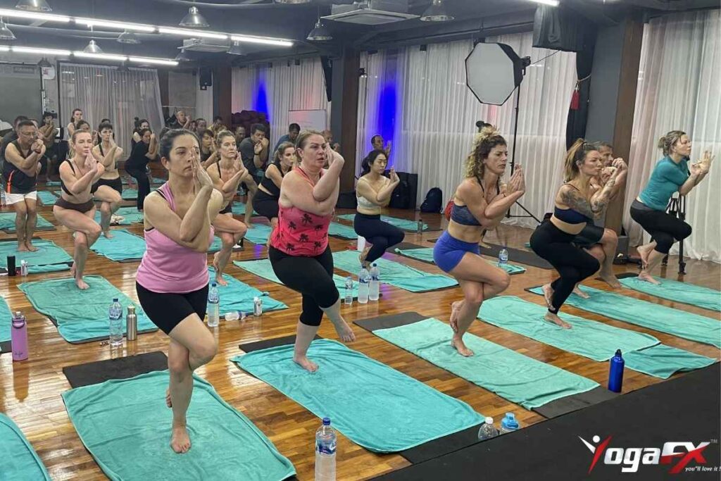 Bikram yoga Eagle Pose arm wrap showing elbows stacked at shoulder height with hands joined above