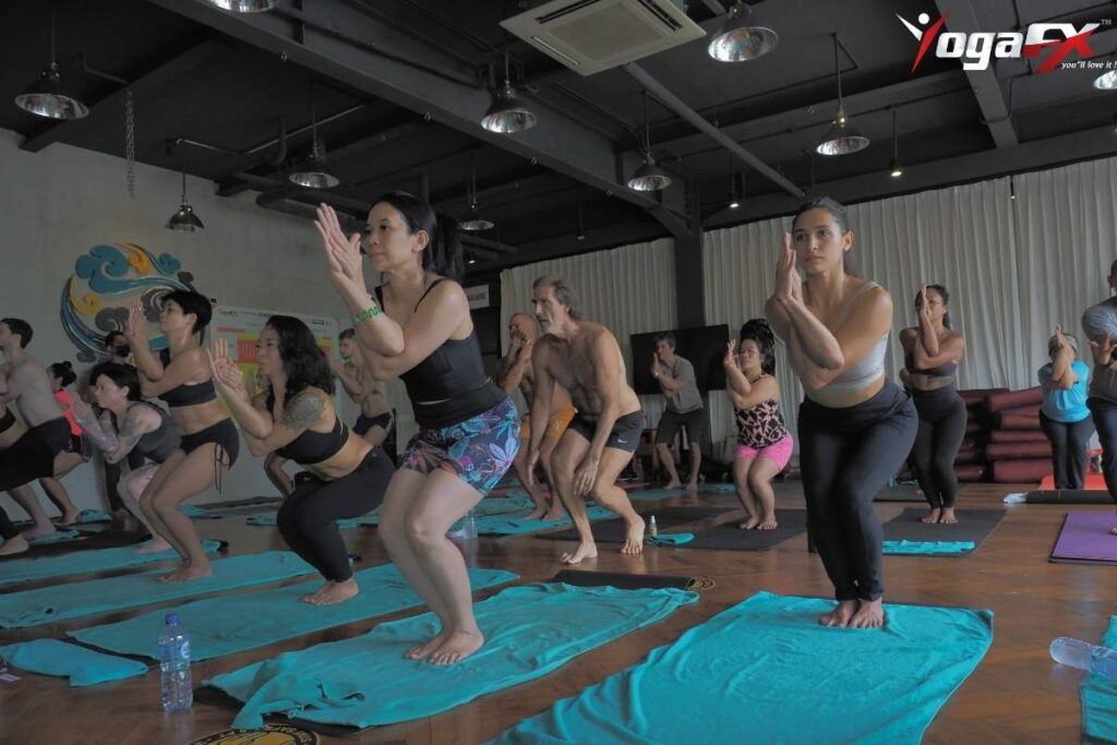 Eagle Pose leg wrap detail showing left foot wrapped around right calf in Bikram yoga standing series