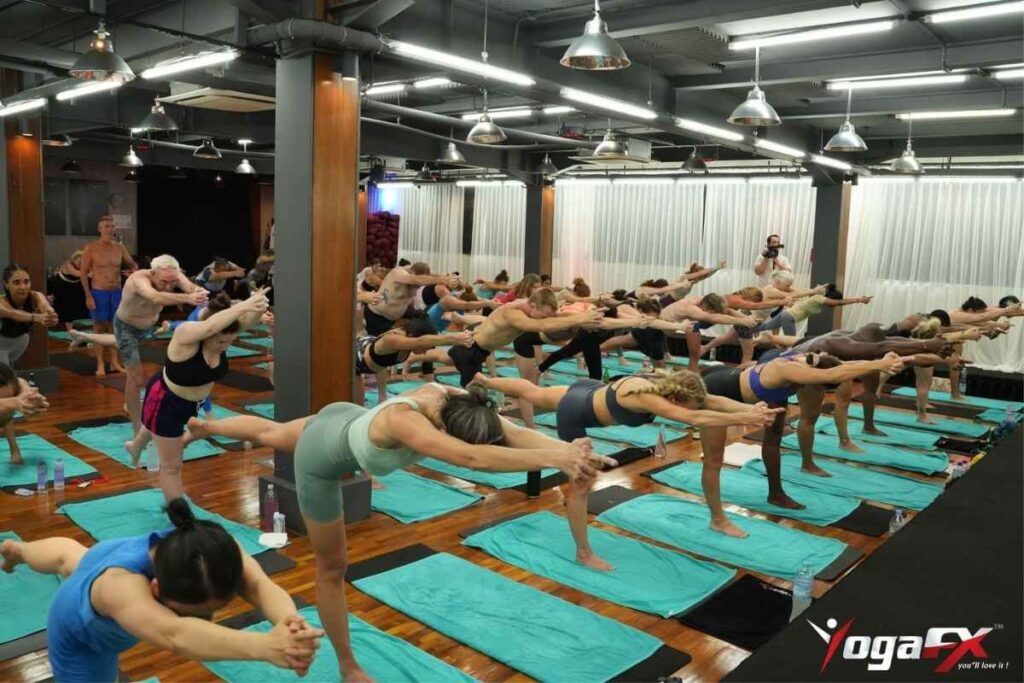 Students receiving live posture correction during Bikram yoga teacher training clinic in Bali