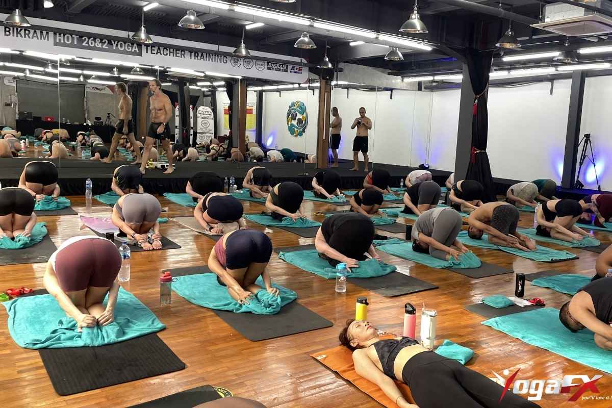 Practitioner demonstrating correct Rabbit Pose Sasangasana in Bikram yoga with forehead to knees and heels gripped