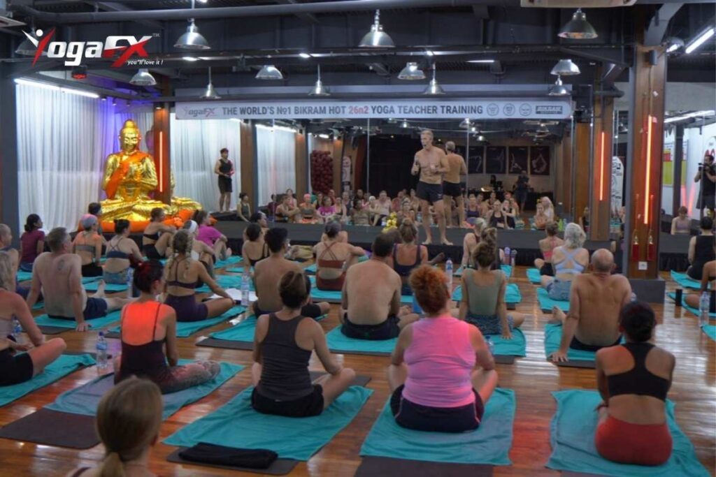 Hot yoga instructor scanning a heated room while teaching, illustrating room-awareness skill beyond dialogue memorization