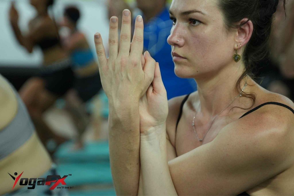 Student practising a Bikram 26&2 posture in a heated Philadelphia studio, compared with a 6-day YogaFX teacher training intensive in Bali